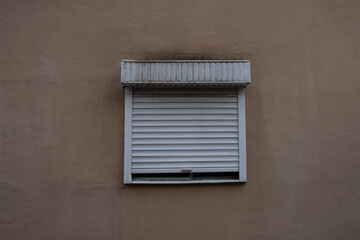 brown wall in the middle with a window covered with white blinds