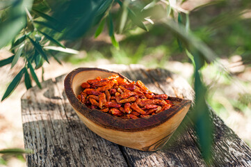 Hot spicy chili pepers. Close up of dried red dry chili pepers in a wooden bowl. Hot chili pepers...