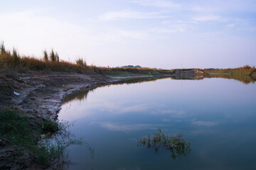 Arial View Canal with green grass and vegetation reflected in the water nearby Padma river in Bangladesh