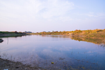 Arial View Canal with green grass and vegetation reflected in the water nearby Padma river in Bangladesh