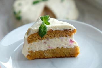 a slice of carrot cake with a mint leaf

