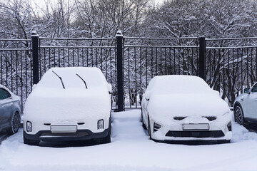 Cars covered by snow in parking lot in cold winter day
