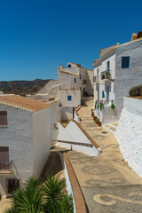 Fototapeta premium Cobblestone streets forming patterns on the ground and white houses in the village of Frigiliana in Malaga province, Andalucia, Spain.
