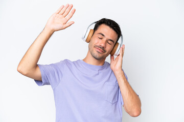 Young handsome man over isolated white background listening music and dancing