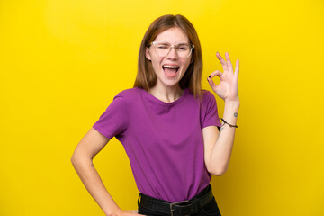 Young English woman isolated on yellow background showing ok sign with fingers