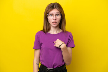 Young English woman isolated on yellow background pointing to oneself