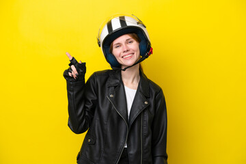 Young English woman with a motorcycle helmet isolated on yellow background showing and lifting a finger in sign of the best