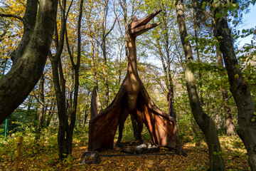 A huge dinosaur model in the forest. Dinosaur in the jungle