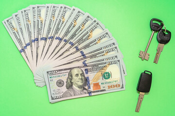 Cash with car and home keys on green background. Investing concept