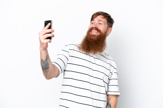 Redhead man with beard isolated on white background making a selfie