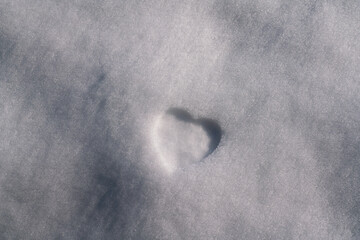 heart shape imprinted in the snow. the footprint for a Merry Christmas. With winter and low temperatures after a good snowfall, you want to ski in the mountains. February Valentine's Day.
