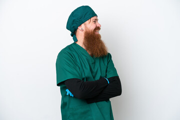 Surgeon redhead man in green uniform isolated on white background looking side
