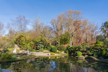 Colorful landscape view in scenic Pierre Baudis japanese garden with trees and boulders reflection...
