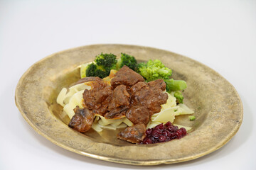  venison ragout with ribbon noodles and broccoli nobly served on a plate