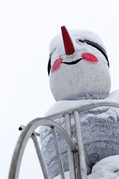 New Year's snowman covered in snow close-up shot.