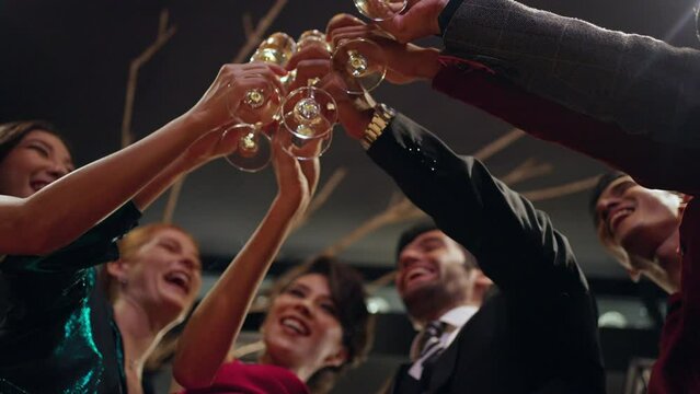 Group of Cheerful people celebrating holiday event party toasting champagne glass together at luxury restaurant bar. Man and woman friends enjoy and fun holiday hangout meeting nightlife at nightclub.