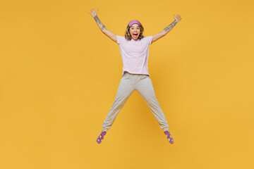 Fototapeta na wymiar Full body fun young woman she wears purple pyjamas jam sleep eye mask rest relax at home jump high with outstretched hands legs isolated on plain yellow background studio portrait Night nap concept.