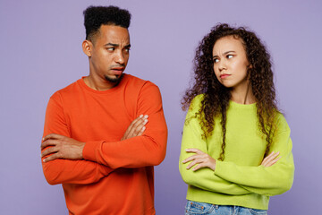 Obraz premium Young offended sad grumpy couple two friends family man woman of African American ethnicity wearing casual clothes together hold hands crossed folded isolated on pastel plain light purple background.