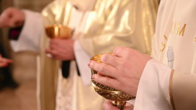 Priest gives holy communion to prayers in cathedral. Midnight Holy Mass on Christmas Eve. Prayer receive the host or bread in church. Eucharist.