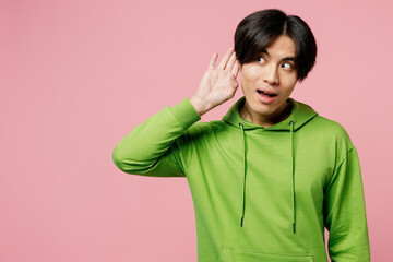 Young fun curious nosy man of Asian ethnicity wear green hoody try to hear you overhear listening...