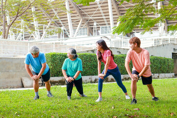 Group of people of various ages exercising outdoors in the morning. They smile happily. Sport...