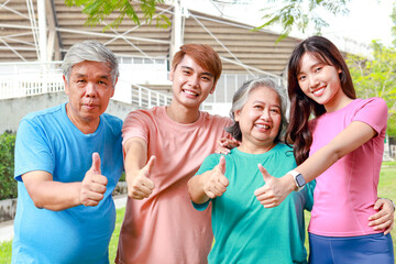 Portrait of a group of people exercising outdoors in the morning They gave thumbs up. and smiling happily. Sport concept, fitness family, health care.