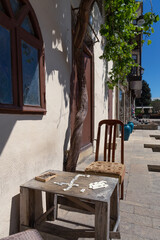 Self made wooden table with dominos and worn chair under tree at house in old city, Baku, Azerbaijan