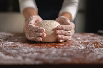 Close up Hand of baker chef is making with flour loaf of dough
