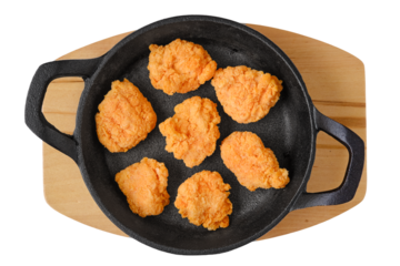 Overhead view of semifinished frozen chicken drumsticks in frying pan