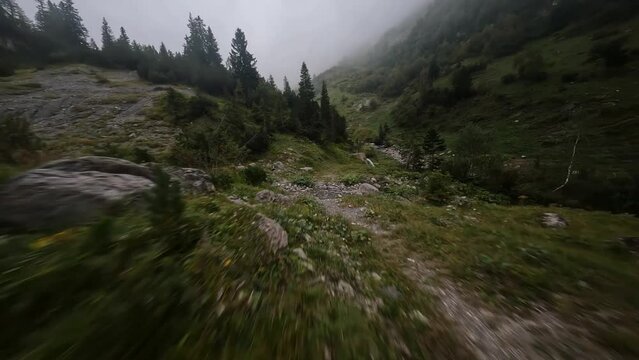 Fast flight over mountain trekking river hiking adventure and nature drone view. Aerial FPV first person view drone. Close acrobatic flying.