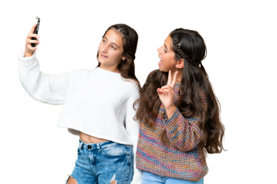 Friends girls over isolated chroma key background making a selfie with the mobile