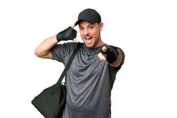 Fototapeta na wymiar Young sport man with sport bag over isolated chroma key background making phone gesture and pointing front