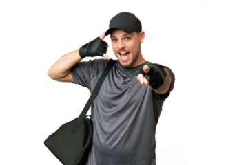 Young sport man with sport bag over isolated chroma key background making phone gesture and pointing front