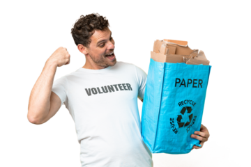 Brazilian man holding a recycling bag full of paper to recycle over isolated chroma key background celebrating a victory