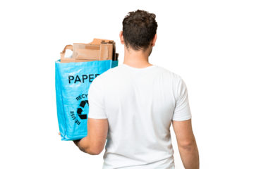 Brazilian man holding a recycling bag full of paper to recycle over isolated chroma key background in back position