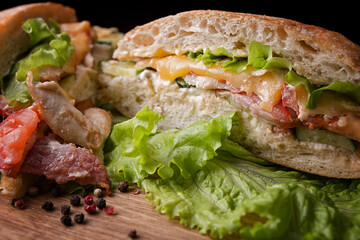sandwich with chicken, bacon, cheese and vegetables