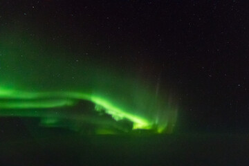 Naklejka na ściany i meble Northern Lights, Aurora Borealis seen from the cockpit above the Atlantic Ocean