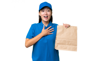 Young Asian woman taking a bag of takeaway food over isolated background surprised and shocked while looking right