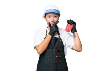 Young caucasian woman wearing an apron and serving fresh cut meat over isolated background thinking