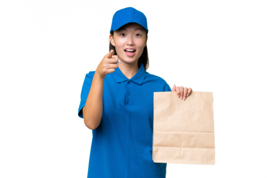 Young Asian woman taking a bag of takeaway food over isolated background surprised and pointing front