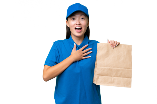 Young Asian woman taking a bag of takeaway food over isolated background surprised and shocked while looking right