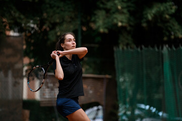 view of sporty woman with tennis racket and with concentrated expression on her face