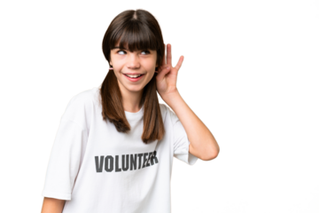 Little volunteer girl over isolated background listening to something by putting hand on the ear