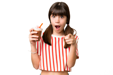 Young man with chocolat milkshake over isolated background surprised and pointing front
