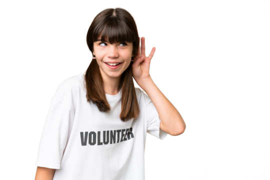 Little volunteer girl over isolated background listening to something by putting hand on the ear