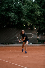 Obraz premium view on tennis ball and woman tennis player with tennis racket before hitting it