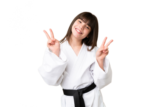 Little Caucasian girl doing karate over isolated background showing victory sign with both hands - Powered by Adobe