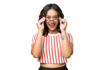 Young Argentinian woman over isolated background with glasses and surprised