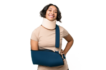 Young argentinian woman wearing neck brace and sling over isolated background posing with arms at hip and smiling