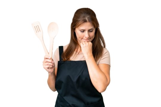 Middle age caucasian woman holding a rolling pin over isolated background having doubts